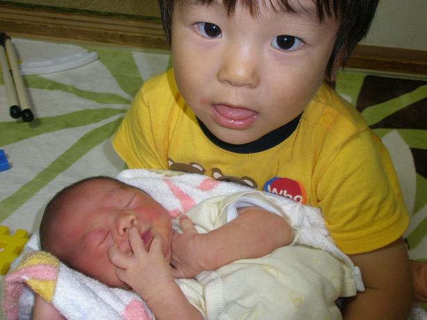 赤ちゃんを抱っこしている子供の写真