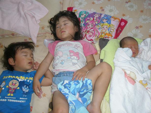 子供が三人熟睡している写真
